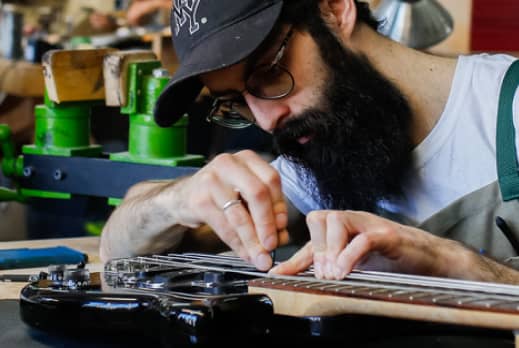 Luthier ajustant une guitare